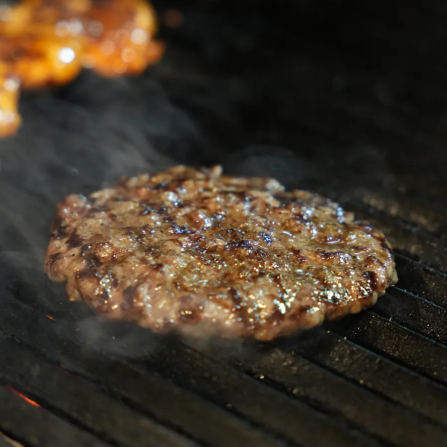 Handmade burger patty on the grill