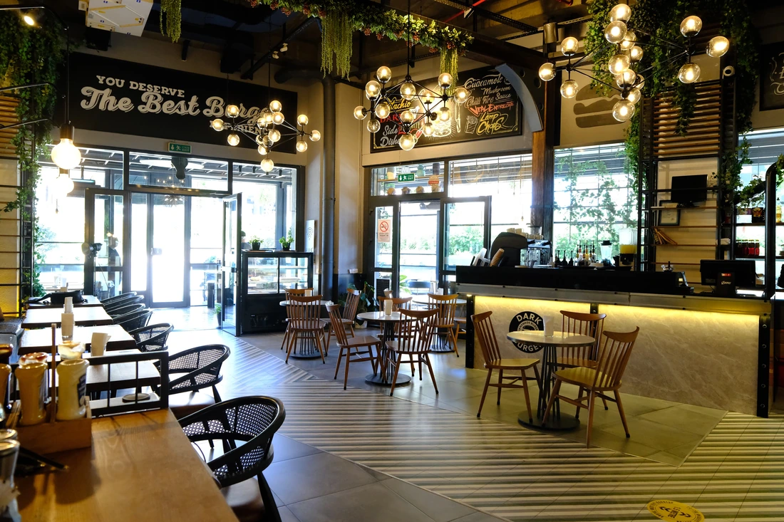 صالتنا: طاولة البار والمصابيح الكروية ولافتة «You deserve the best burger»